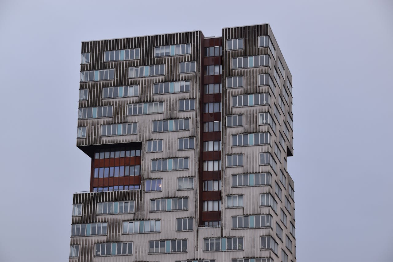 A striking modern high-rise building in Amsterdam, featuring unique architectural design against the sky.
